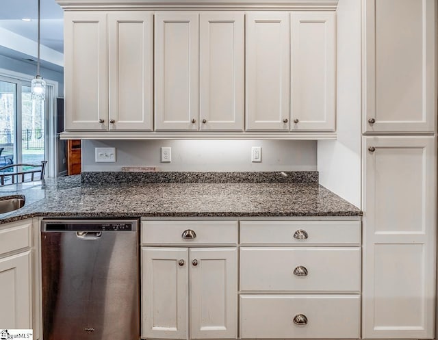 kitchen featuring dark stone counters, stainless steel dishwasher, and white cabinetry