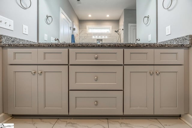 bathroom with double vanity, tiled shower, marble finish floor, and recessed lighting