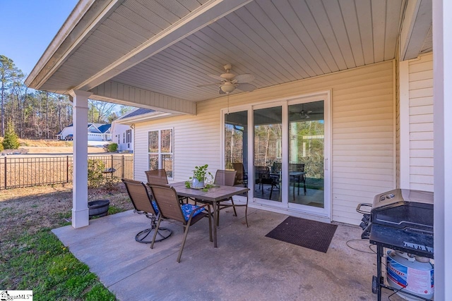 view of patio with outdoor dining space, ceiling fan, and fence