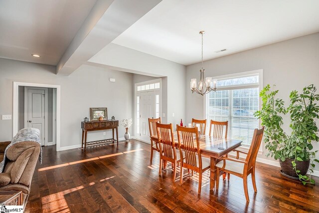 dining space with baseboards, a notable chandelier, and dark wood-style floors