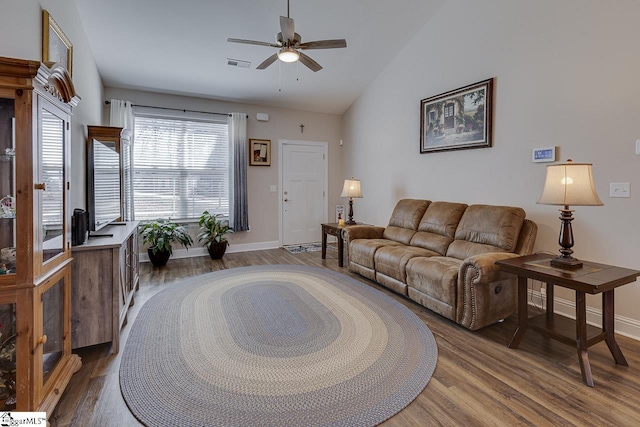 living area with visible vents, lofted ceiling, and wood finished floors