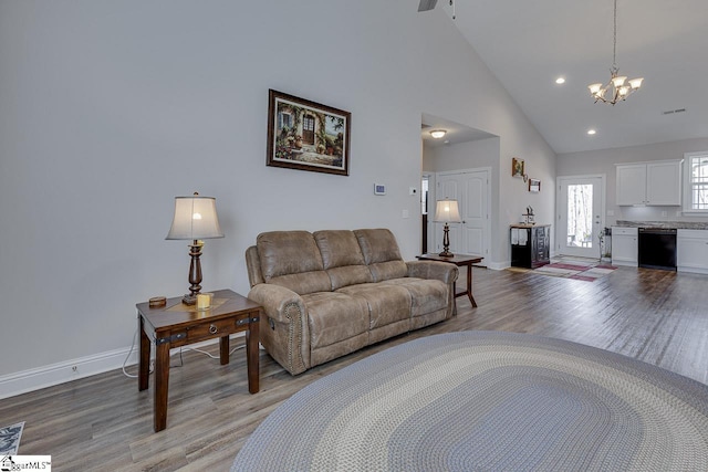 living area with high vaulted ceiling, light wood-style flooring, recessed lighting, baseboards, and a chandelier