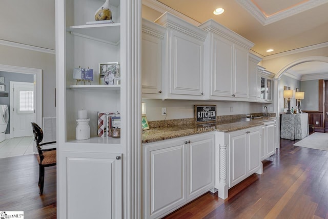 kitchen with dark wood finished floors, white cabinets, visible vents, and ornamental molding