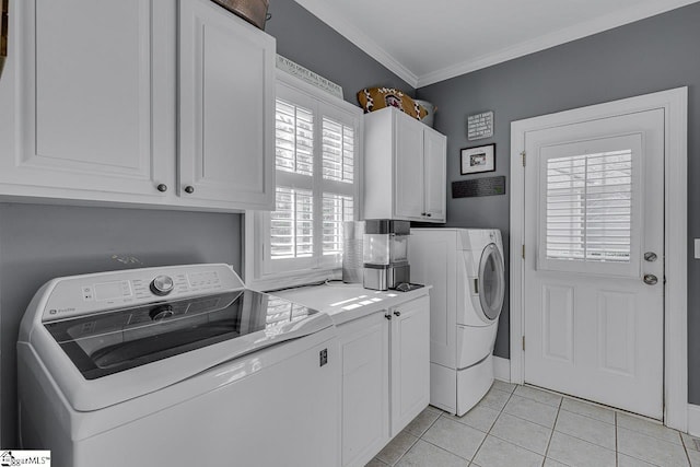 washroom with light tile patterned floors, cabinet space, crown molding, and washer and clothes dryer