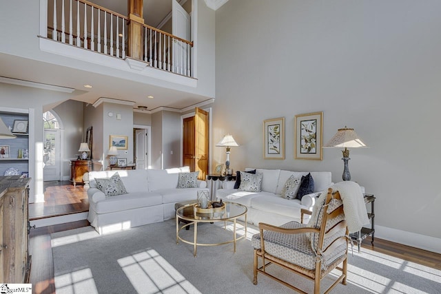 living room featuring wood finished floors, baseboards, recessed lighting, a towering ceiling, and crown molding