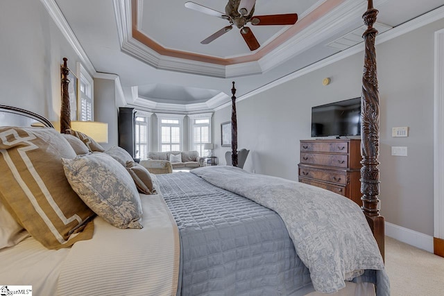 carpeted bedroom with crown molding, a ceiling fan, a raised ceiling, and baseboards