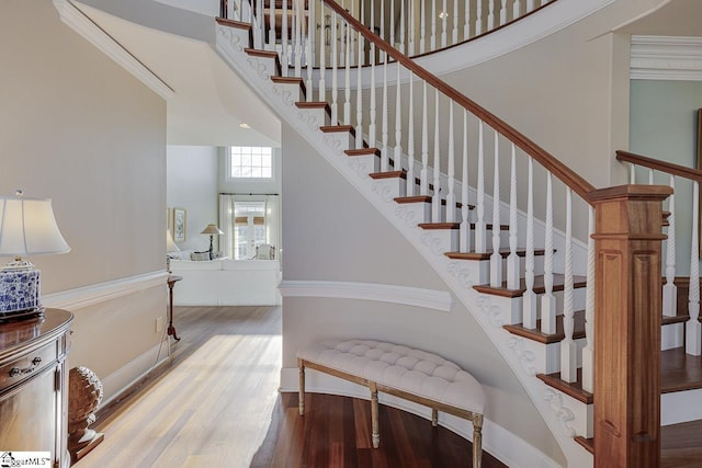 staircase featuring a high ceiling and wood finished floors