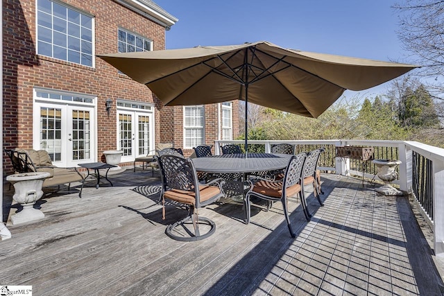 wooden terrace with outdoor dining area and french doors