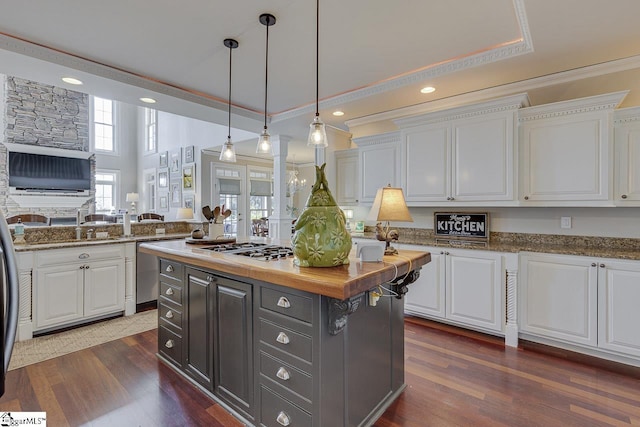 kitchen with appliances with stainless steel finishes, dark wood-style floors, a center island, and white cabinetry