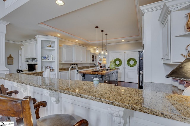 kitchen with ornate columns, open shelves, a tray ceiling, recessed lighting, and crown molding