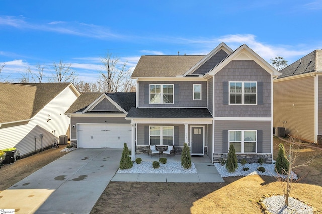 craftsman-style house featuring a porch, central AC unit, driveway, stone siding, and an attached garage