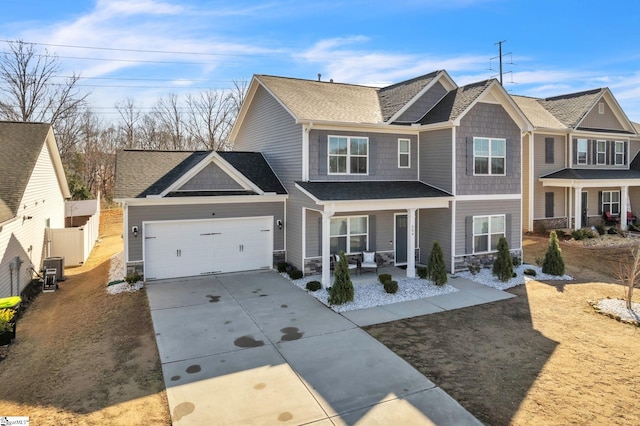 view of front of property with stone siding, a porch, concrete driveway, and an attached garage