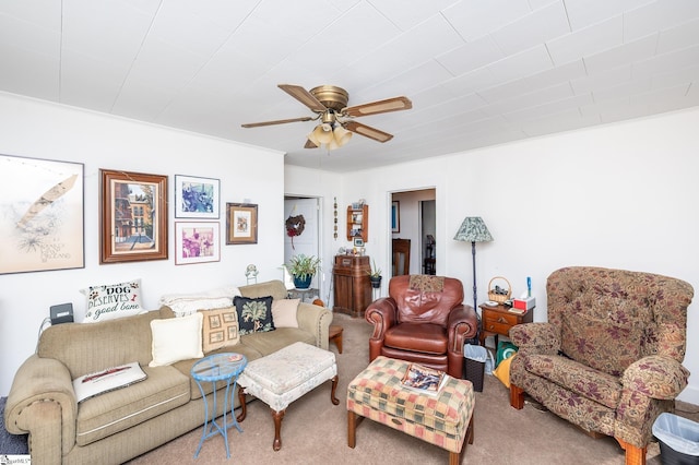 living area with a ceiling fan and carpet