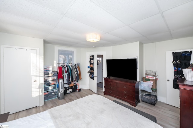 bedroom with wood finished floors, a closet, and a drop ceiling