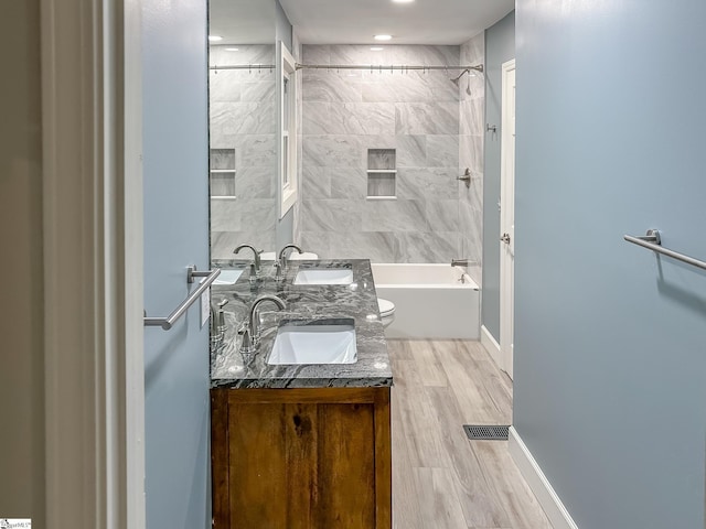 full bath featuring a sink, shower / bath combination, baseboards, and wood finished floors