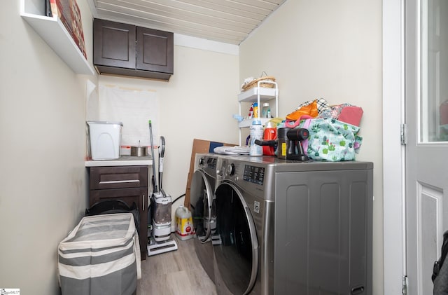 laundry room featuring cabinet space, washer and dryer, and wood finished floors