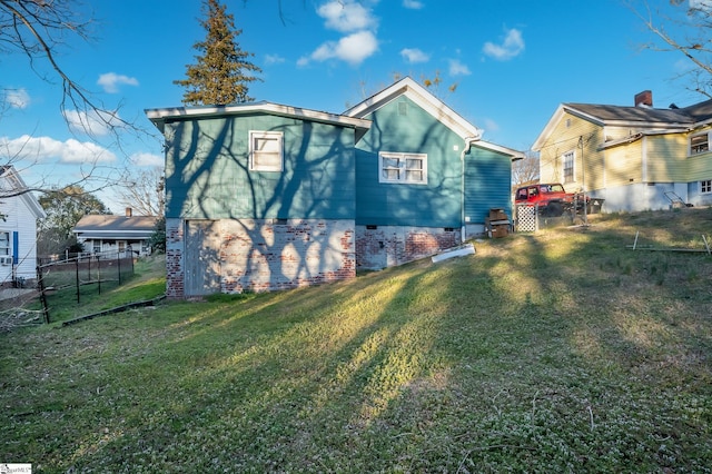 back of property featuring a lawn and fence