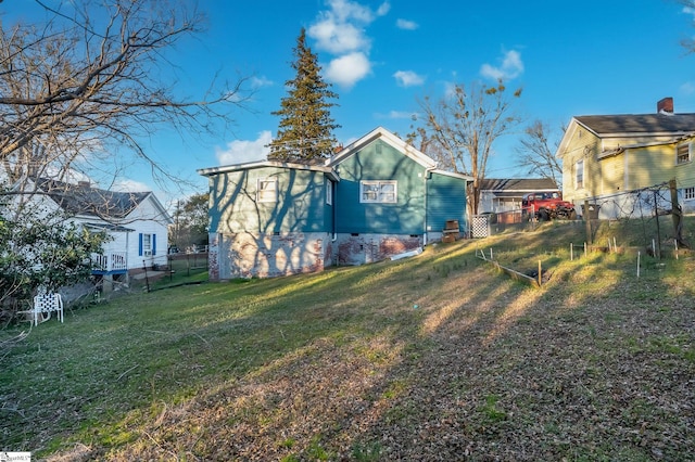 rear view of property with a yard and fence