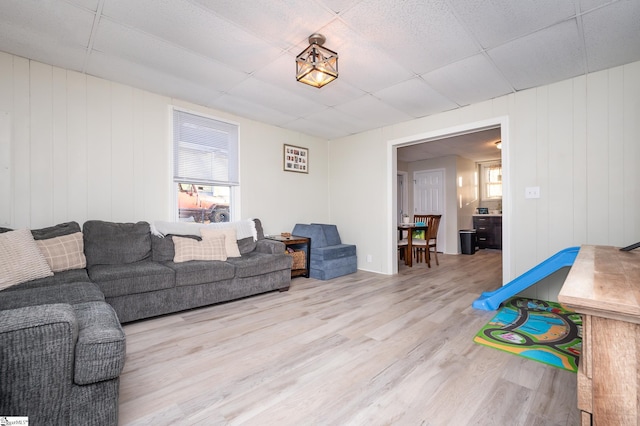 living area featuring a drop ceiling and wood finished floors