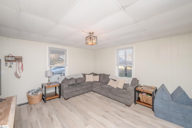 living room featuring a paneled ceiling and wood finished floors