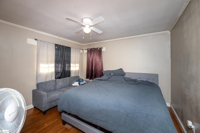 bedroom featuring ceiling fan, wood finished floors, baseboards, and ornamental molding