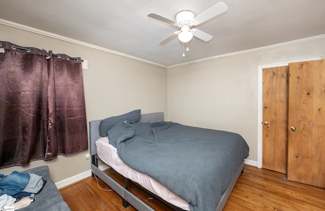 bedroom featuring ornamental molding, ceiling fan, baseboards, and wood finished floors