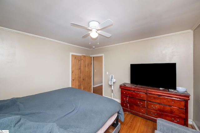 bedroom featuring ceiling fan, wood finished floors, and ornamental molding