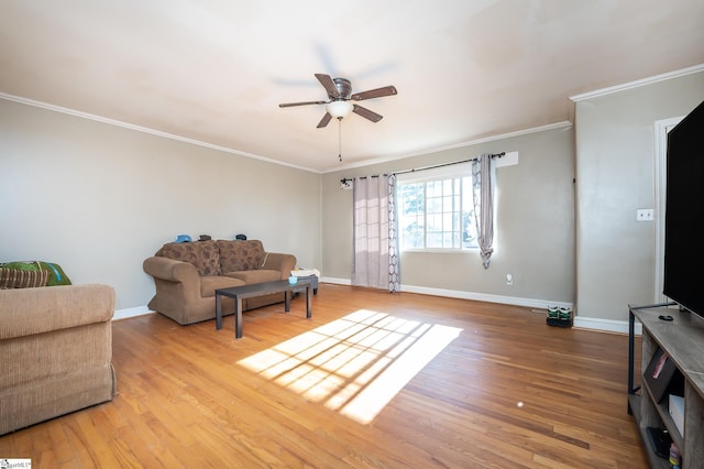 living area with baseboards, wood finished floors, and crown molding