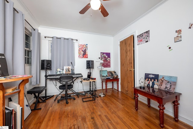 office area with baseboards, wood finished floors, ornamental molding, and a ceiling fan