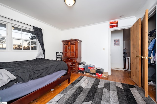 bedroom featuring wood finished floors and ornamental molding