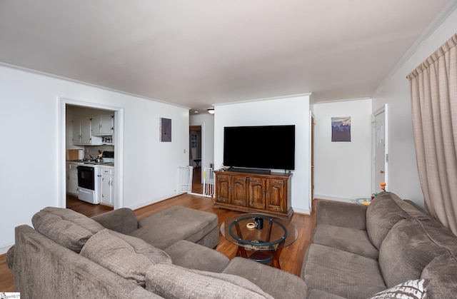 living room featuring baseboards, dark wood-type flooring, and crown molding