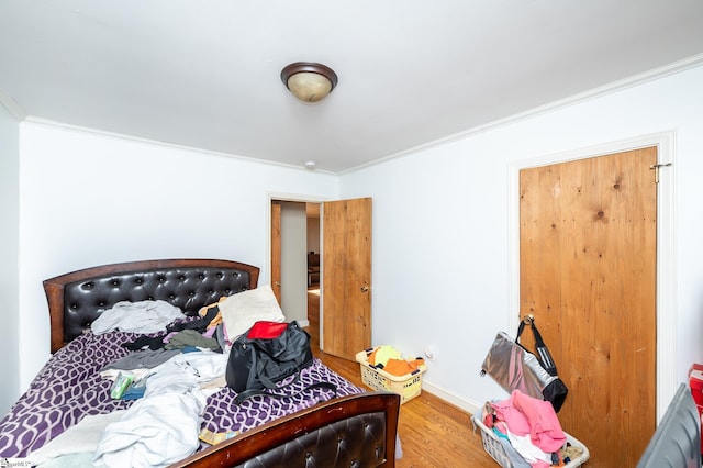 bedroom featuring crown molding, baseboards, and wood finished floors