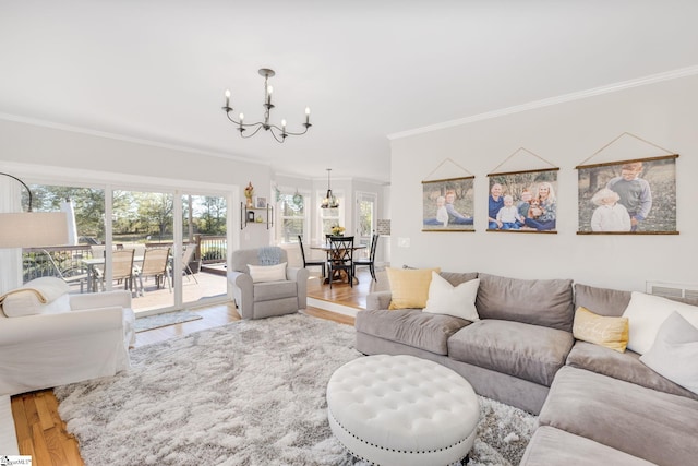 living room featuring an inviting chandelier, wood finished floors, and crown molding