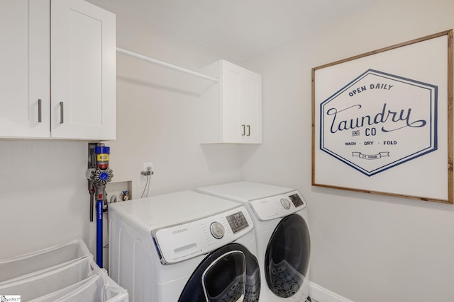 clothes washing area with washer and dryer and cabinet space