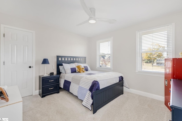 bedroom with light colored carpet, baseboards, and ceiling fan