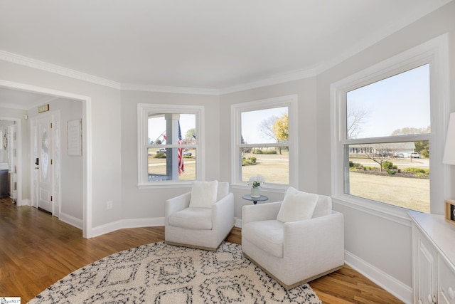 sitting room featuring baseboards, light wood-style floors, and ornamental molding