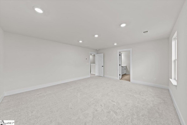 interior space with visible vents, recessed lighting, light colored carpet, and baseboards