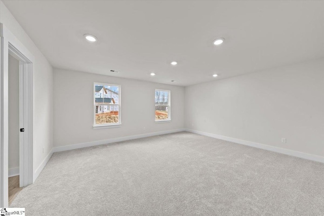 empty room with light colored carpet, recessed lighting, baseboards, and visible vents