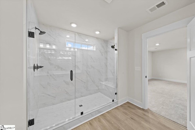 full bath featuring wood finished floors, visible vents, a marble finish shower, baseboards, and recessed lighting