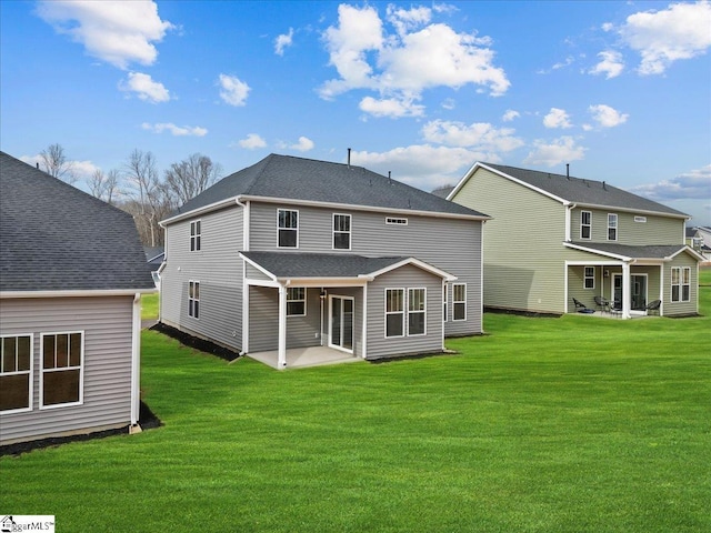 back of property featuring a patio, a lawn, and roof with shingles