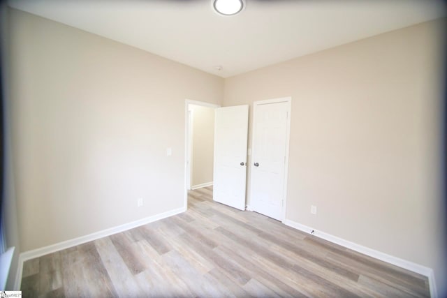 unfurnished bedroom with a closet, baseboards, and wood finished floors