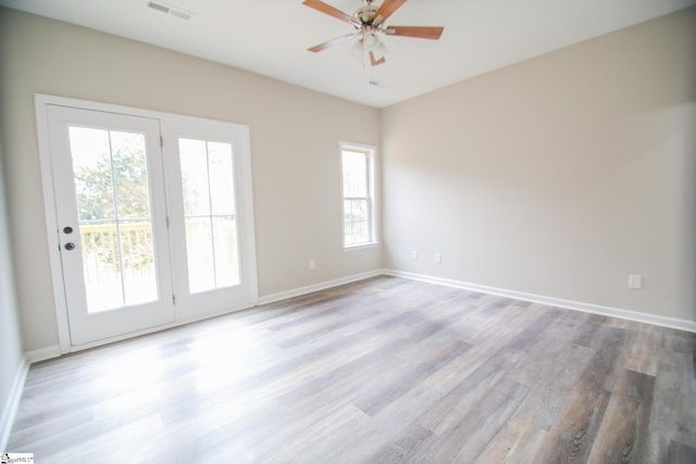 empty room with light wood-style flooring, baseboards, and visible vents