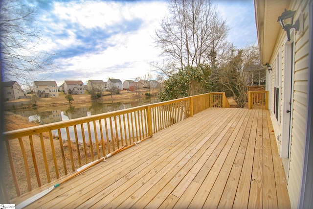 wooden terrace featuring a residential view and a water view