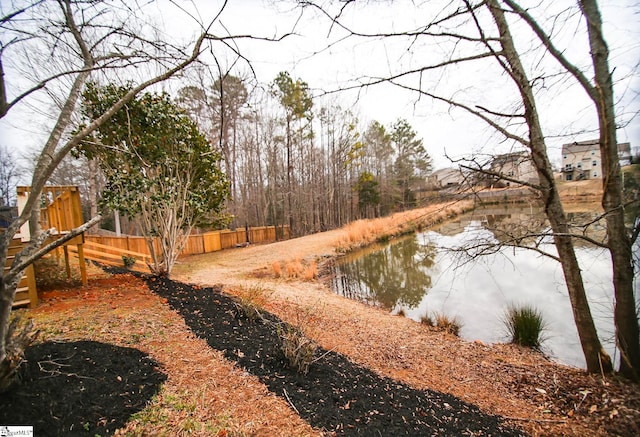 view of yard featuring fence and a water view