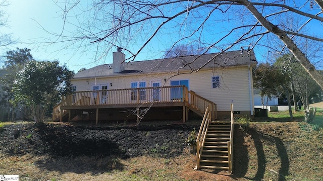 rear view of property with crawl space, a chimney, stairs, and a deck