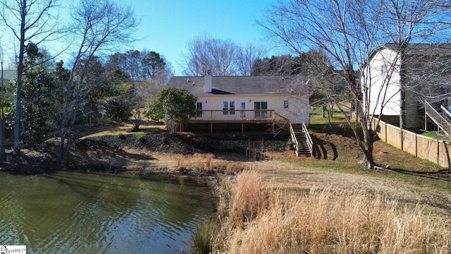 rear view of house featuring stairway, a deck, and fence