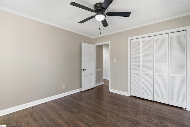 unfurnished bedroom featuring dark wood-style floors, a textured ceiling, crown molding, and baseboards