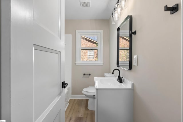 full bathroom featuring vanity, wood finished floors, visible vents, baseboards, and toilet