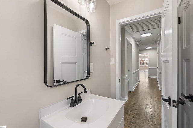 bathroom with vanity, wood finished floors, and baseboards