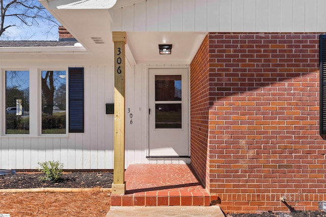 entrance to property featuring brick siding